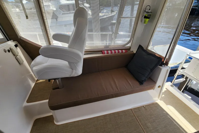 Slide: The Image of Interior of 2003 Endeavour 44 TrawlerCat with cushioned seating and helm chair. - 15