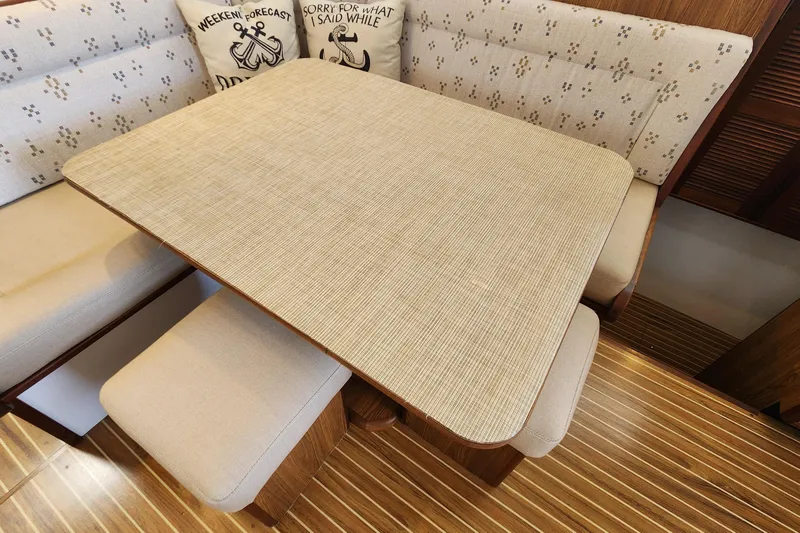 Slide: The Image of Dining area in 2003 Endeavour 44 TrawlerCat with cushioned seating and wooden table. - 20