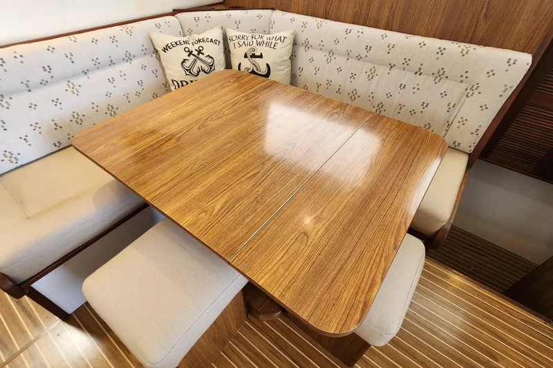 Slide: The Image of Cozy dining area in 2003 Endeavour 44 TrawlerCat with wooden table and cushioned seating. - 21