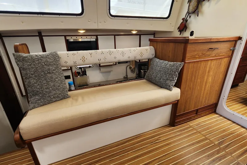Slide: The Image of Interior of 2003 Endeavour 44 TrawlerCat with cushioned seating and wooden cabinetry. - 25