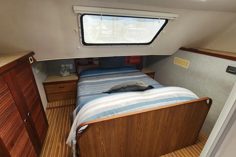 Slide: The Image of Cozy cabin interior of 2003 Endeavour 44 TrawlerCat with striped bedding and wooden furnishings. - 28