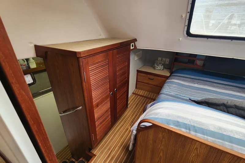 Slide: The Image of Cozy cabin interior of 2003 Endeavour 44 TrawlerCat with wooden furniture and striped bedding. - 29