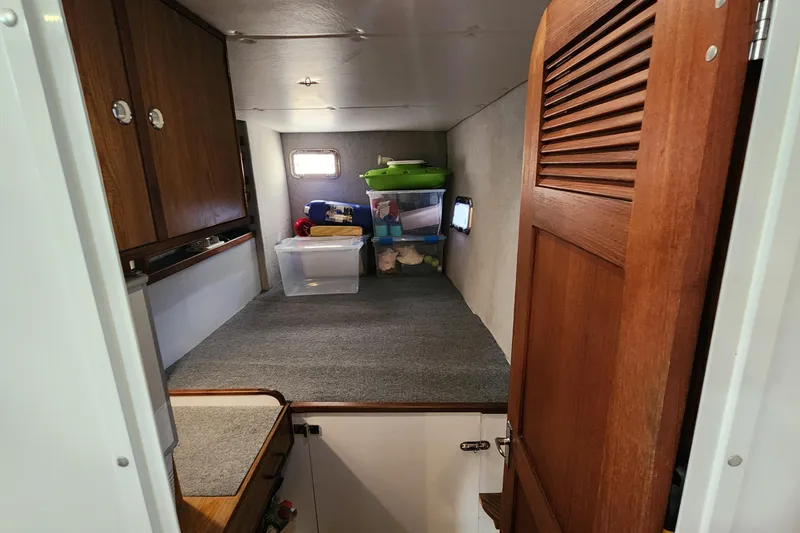 Slide: The Image of Interior storage space of 2003 Endeavour 44 TrawlerCat with wooden cabinets and carpeted floor. - 38
