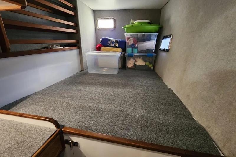Slide: The Image of Interior storage space of 2003 Endeavour 44 TrawlerCat with organized containers and carpeted flooring. - 39