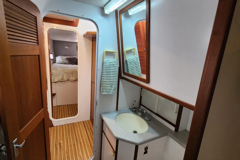 Slide: The Image of Bathroom interior of 2003 Endeavour 44 TrawlerCat with sink, mirror, and wooden accents. - 43
