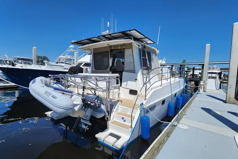 Slide: The Image of 2003 Endeavour 44 TrawlerCat docked with inflatable dinghy and blue fenders. - 5