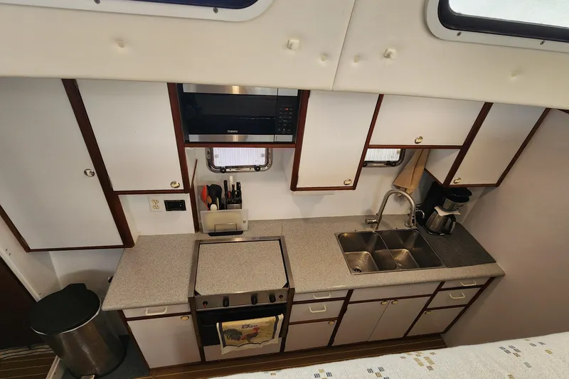 Slide: The Image of Compact kitchen in a 2003 Endeavour 44 TrawlerCat, featuring modern appliances and ample storage. - 53