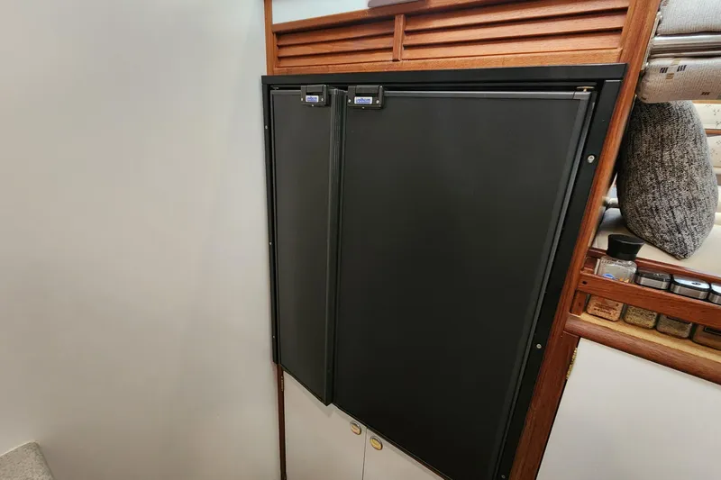 Slide: The Image of Built-in refrigerator on 2003 Endeavour 44 TrawlerCat, featuring wooden cabinetry and spice storage. - 58