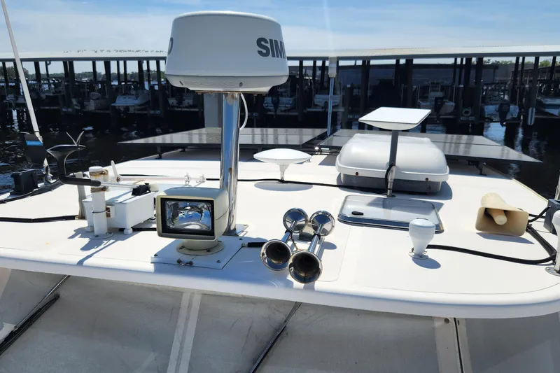 Slide: The Image of 2003 Endeavour 44 TrawlerCat deck with radar, spotlight, and solar panels in marina setting. - 64