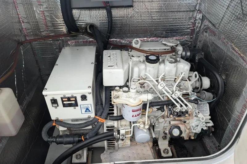 Slide: The Image of Engine compartment of a 2003 Endeavour 44 TrawlerCat, showcasing mechanical components and wiring. - 74