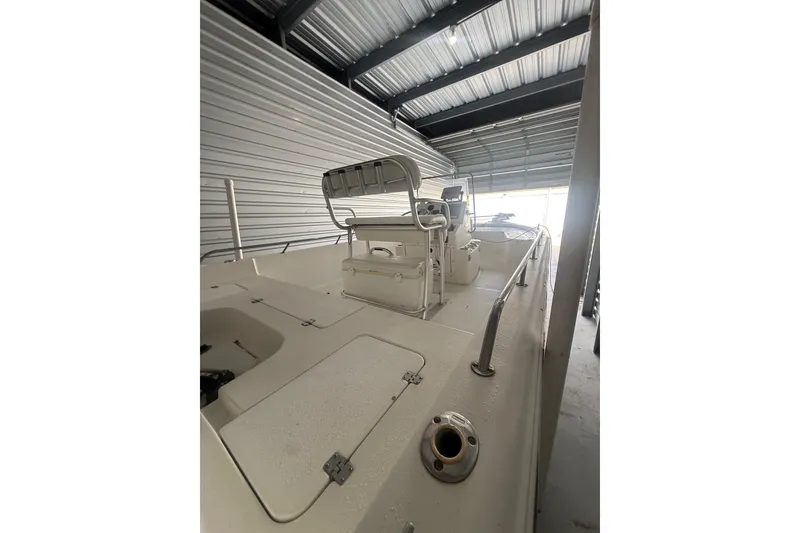 Slide: The Image of 2005 Sea Pro SV2400CC Bay Boat in storage, showcasing spacious deck and helm. - 10
