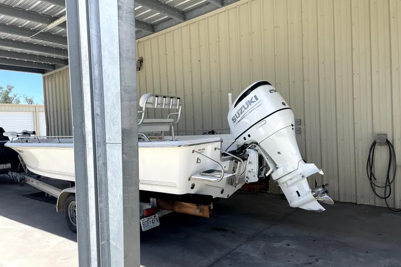 Slide: The Image of 2005 Sea Pro SV2400CC Bay Boat with Suzuki outboard motor in covered storage. - 2