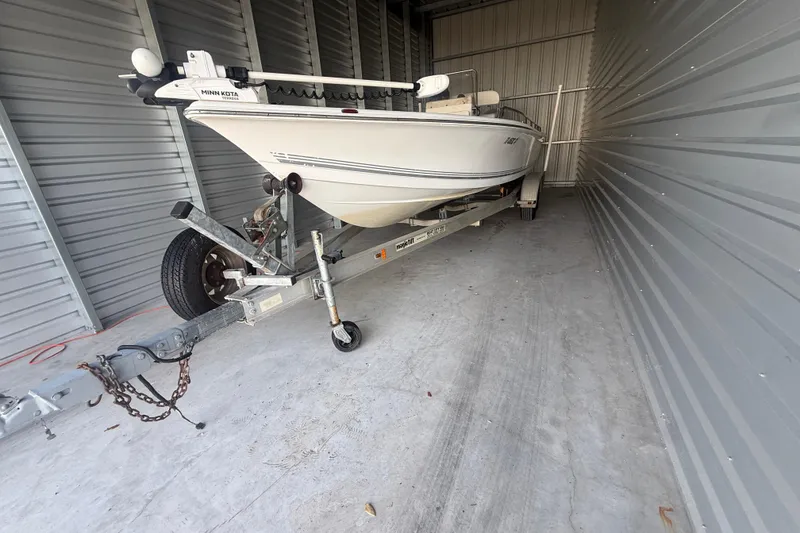 Slide: The Image of 2005 Sea Pro SV2400CC Bay Boat stored in a metal storage unit on a trailer. - 5