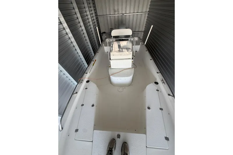 Slide: The Image of 2005 Sea Pro SV2400CC Bay Boat in storage, showcasing spacious deck and seating. - 6