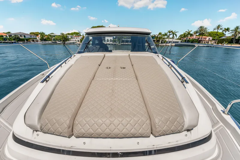 Slide: The Image of 2020 Jeanneau NC 37 yacht with cushioned deck, docked by waterfront homes. - 13