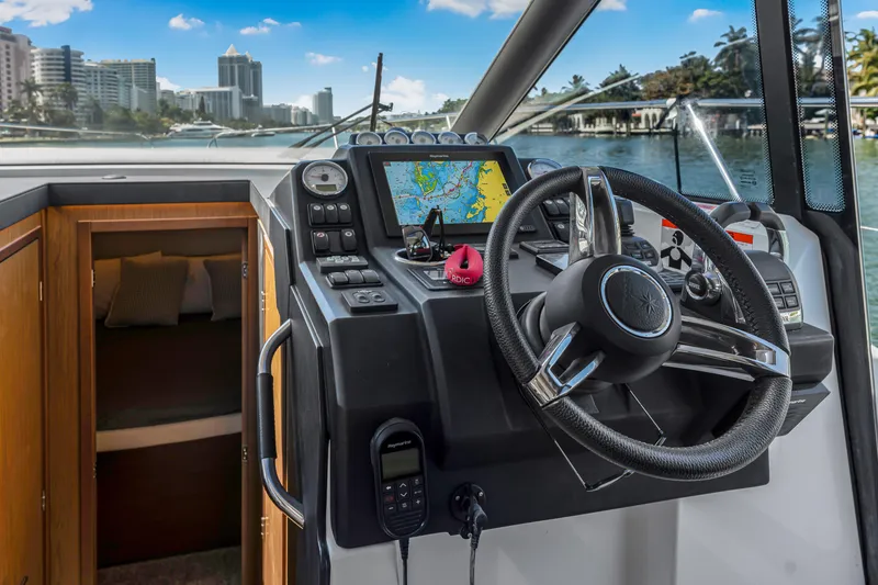Slide: The Image of Helm of 2020 Jeanneau NC 37 yacht with navigation system and cityscape view. - 18