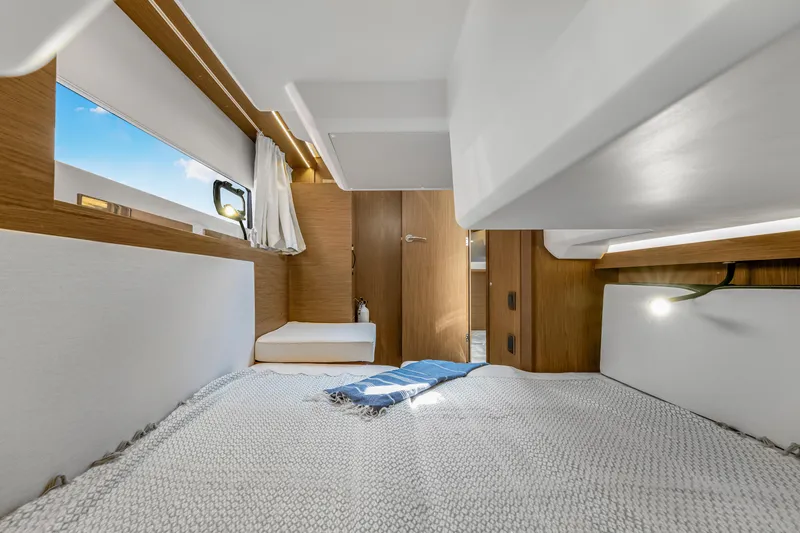 Slide: The Image of Interior cabin of 2020 Jeanneau NC 37 yacht, featuring cozy bedding and modern wood finishes. - 32