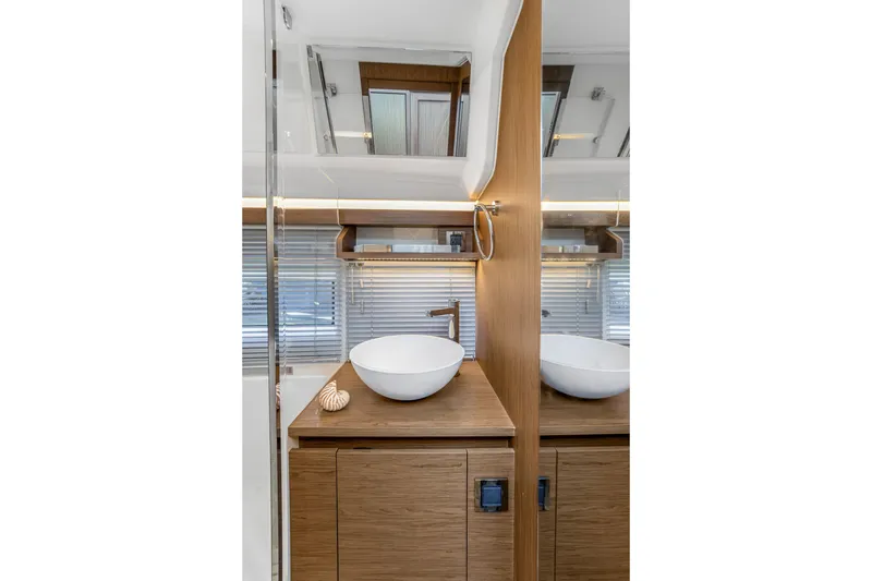 Slide: The Image of Modern bathroom interior on 2020 Jeanneau NC 37 yacht, featuring sleek wood cabinetry and vessel sink. - 35