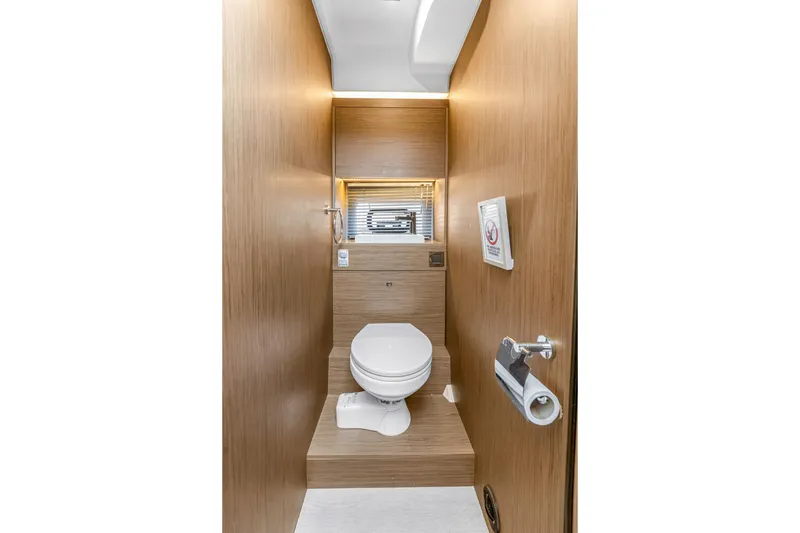 Slide: The Image of Modern bathroom interior on 2020 Jeanneau NC 37 yacht, featuring sleek wood paneling and compact design. - 37