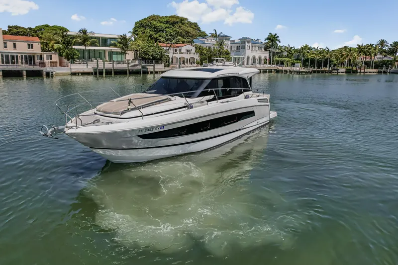 Slide: The Image of 2020 Jeanneau NC 37 yacht cruising in a scenic waterfront setting. - 4