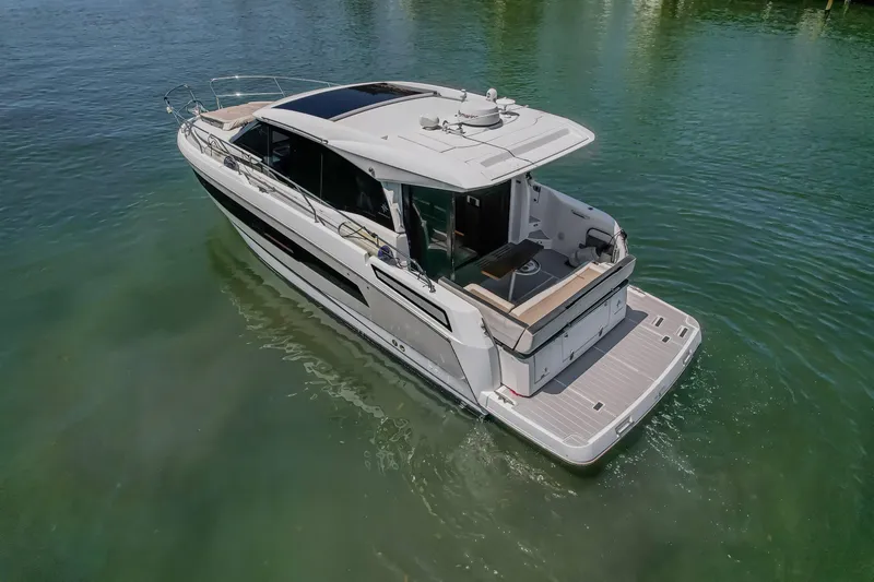 Slide: The Image of 2020 Jeanneau NC 37 yacht cruising on clear water, showcasing sleek design and spacious deck. - 6