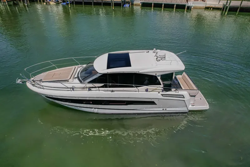 Slide: The Image of 2020 Jeanneau NC 37 yacht on calm green water, showcasing sleek design and modern features. - 7