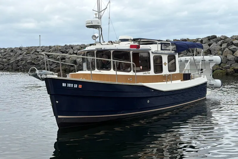 The Image of 2014 Ranger Tugs R-25 SC boat docked near rocky shoreline. - 0