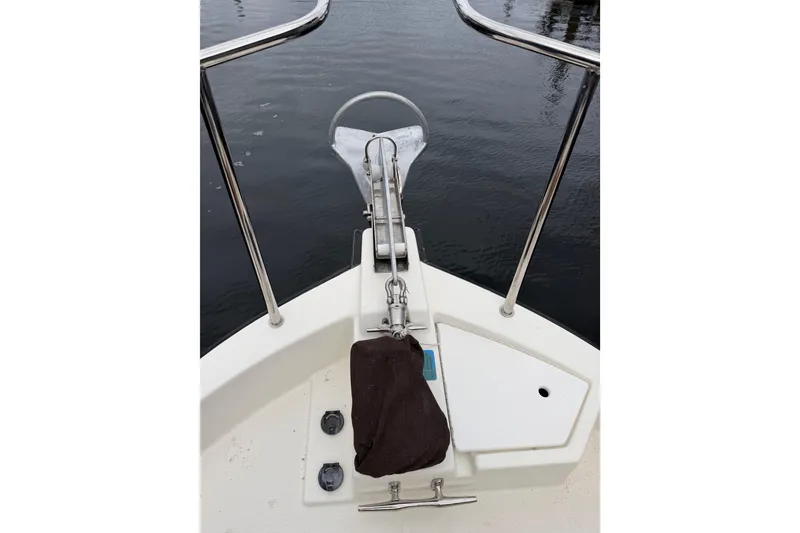 Slide: The Image of Bow of 2014 Ranger Tugs R-25 SC with anchor and railing, docked on calm water. - 10