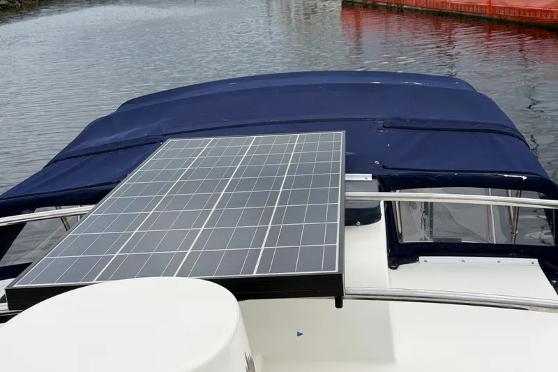 Slide: The Image of 2014 Ranger Tugs R-25 SC with solar panel on deck, docked by water. - 16