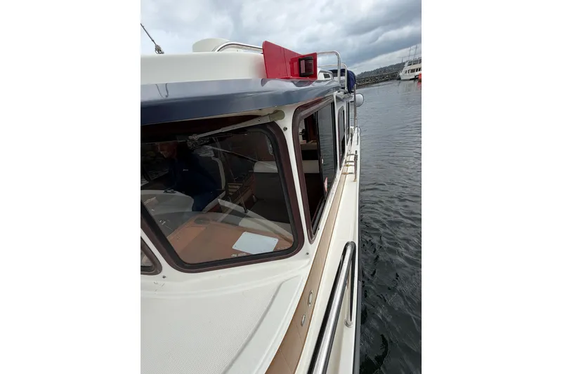 Slide: The Image of 2014 Ranger Tugs R-25 SC boat docked on a cloudy day. - 17