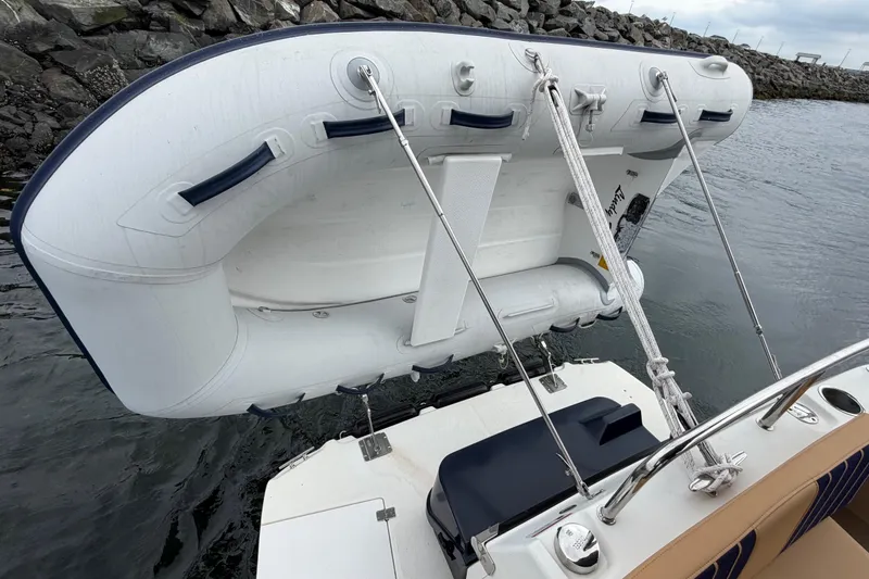 Slide: The Image of Inflatable dinghy mounted on a 2014 Ranger Tugs R-25 SC boat, near rocky shoreline. - 18