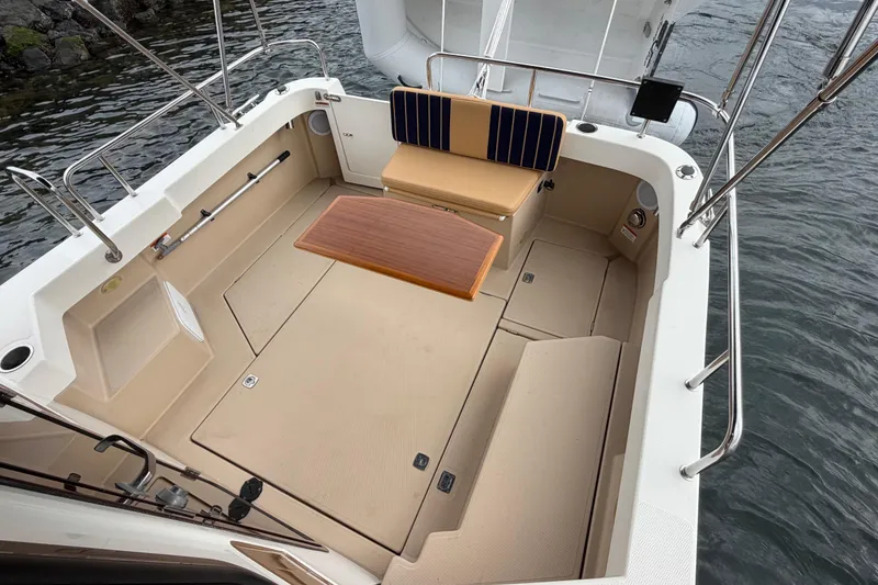 Slide: The Image of 2014 Ranger Tugs R-25 SC boat cockpit with seating and table, near water. - 19