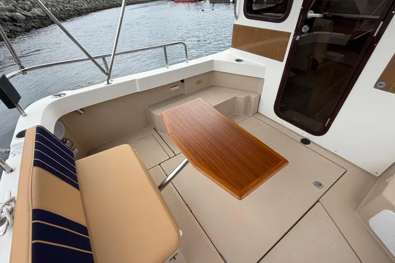 Slide: The Image of 2014 Ranger Tugs R-25 SC boat interior with seating and wooden table. - 20