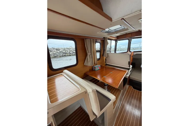 Slide: The Image of Interior of 2014 Ranger Tugs R-25 SC boat with wooden table and seating. - 23