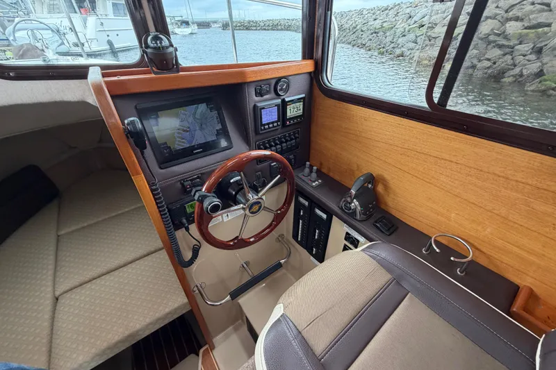Slide: The Image of 2014 Ranger Tugs R-25 SC helm with navigation equipment and wooden accents. - 29