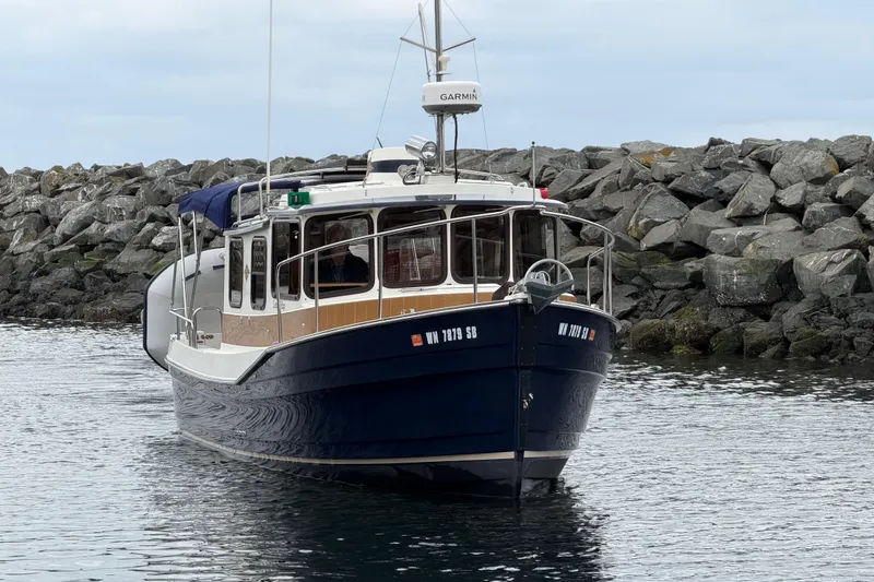 Slide: The Image of 2014 Ranger Tugs R-25 SC boat docked near rocky shoreline. - 3