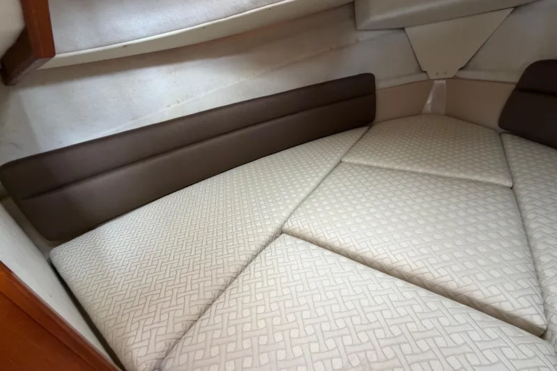 Slide: The Image of 2014 Ranger Tugs R-25 SC cabin interior with patterned cushions and brown accents. - 36