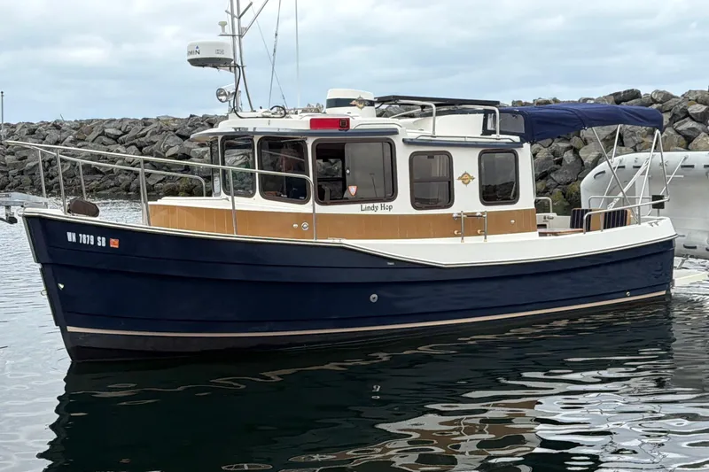 Slide: The Image of 2014 Ranger Tugs R-25 SC boat docked in a marina, featuring a blue hull. - 5