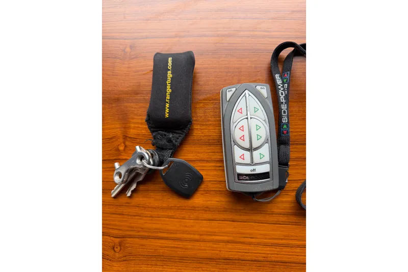 Slide: The Image of Remote control and keys for 2014 Ranger Tugs R-25 SC on wooden surface. - 50