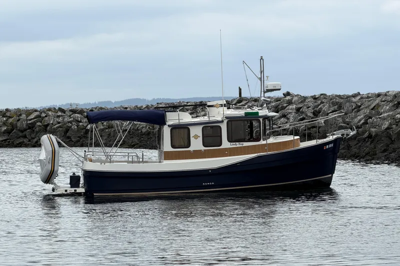 Slide: The Image of 2014 Ranger Tugs R-25 SC boat docked near rocky shoreline. - 9