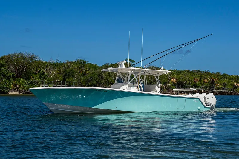 The Image of 2023 SeaVee 390B boat cruising on a sunny day, surrounded by lush greenery. - 0