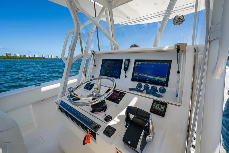 Slide: The Image of 2023 SeaVee 390B boat dashboard with navigation screens and steering wheel on open water. - 22