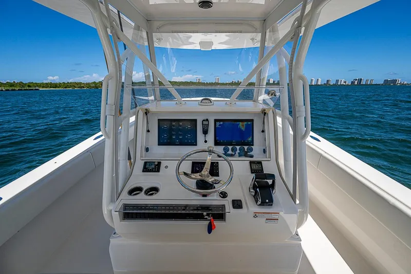Slide: The Image of 2023 SeaVee 390B boat helm with navigation screens on open water. - 24