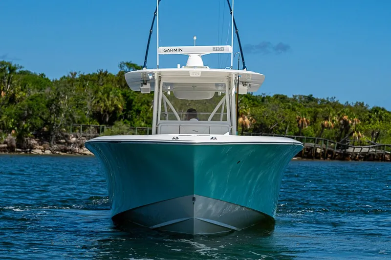 Slide: The Image of 2023 SeaVee 390B boat on water, front view, with lush greenery background. - 32