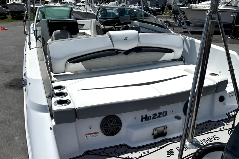 Slide: The Image of 2020 Four Winns HD220 boat interior with white seating and cup holders. - 12