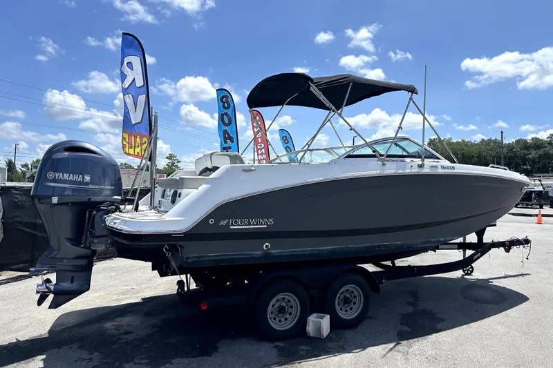 Slide: The Image of 2020 Four Winns HD220 boat on trailer with Yamaha outboard motor, displayed for sale. - 2