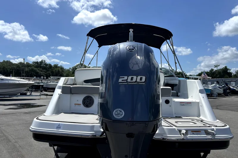 Slide: The Image of 2020 Four Winns HD220 boat with Yamaha 200 engine, parked outdoors under blue sky. - 4