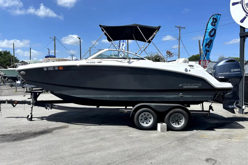 Slide: The Image of 2020 Four Winns HD220 boat on trailer under clear blue sky. - 7