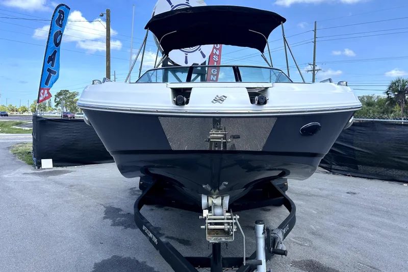 Slide: The Image of 2020 Four Winns HD220 boat on trailer, displayed outdoors with blue sky background. - 9