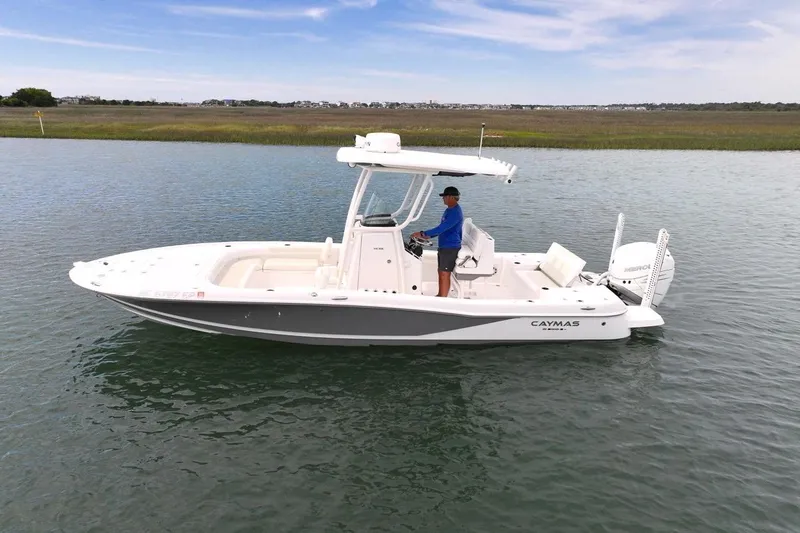 The Image of 2020 Caymas 26 HB boat on calm water with a person at the helm. - 0